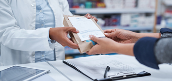 A pharmacist handing a patient a prescription