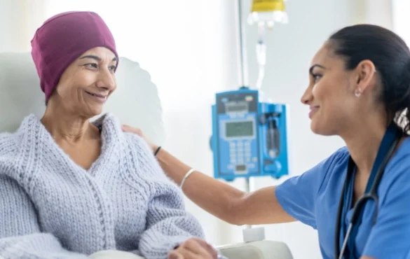 A cancer patient smiles and talks to her physician