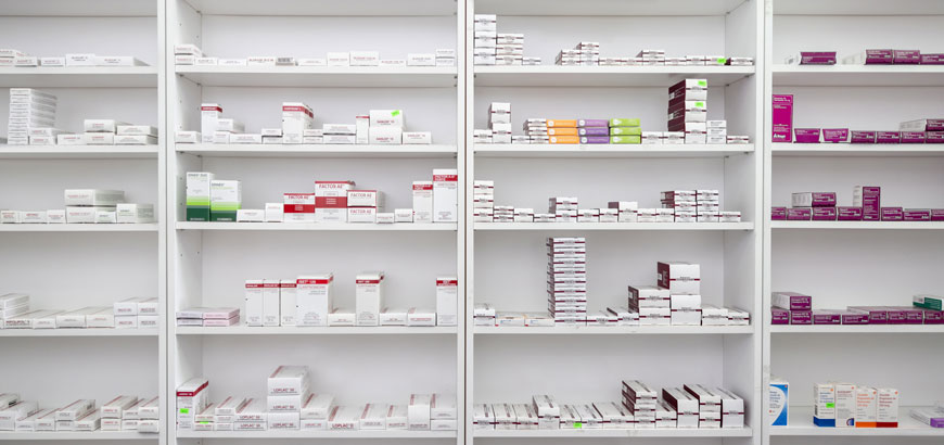A shelf full of boxes containing prescription medications