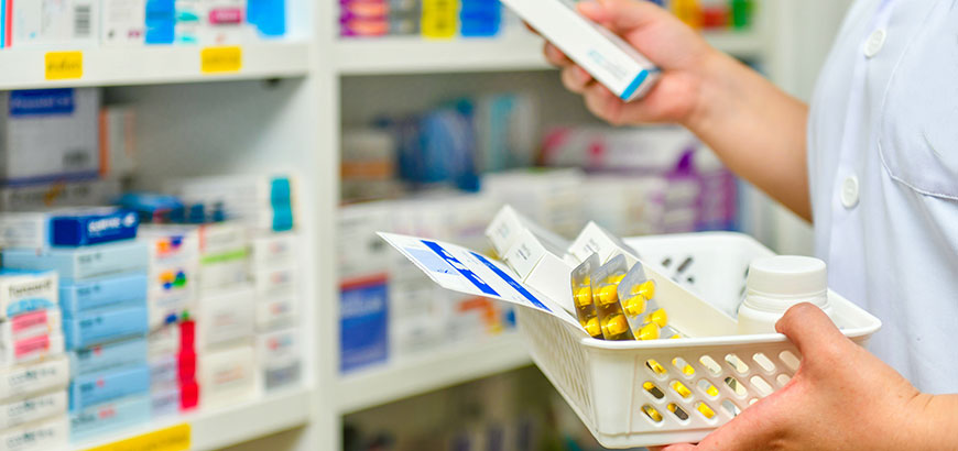 A pharmacist holding a basket of pills