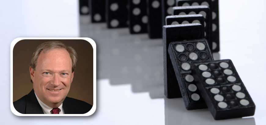 Headshot of Andy Wilson with a row of dominoes behind it.<br>  