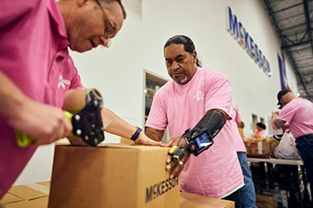 Workers sealing a box in a distribution center