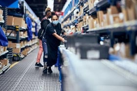 A McKesson employee pushes boxes down an assembly line