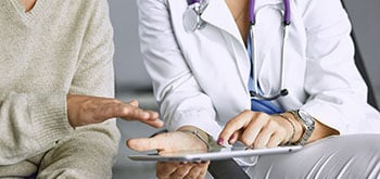 A doctor and patient looking at a tablet