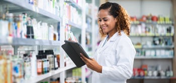 A female pharmacist holding a tablet and smiling