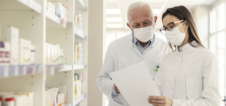 Two pharmacists in a pharmacy reviewing drug orders