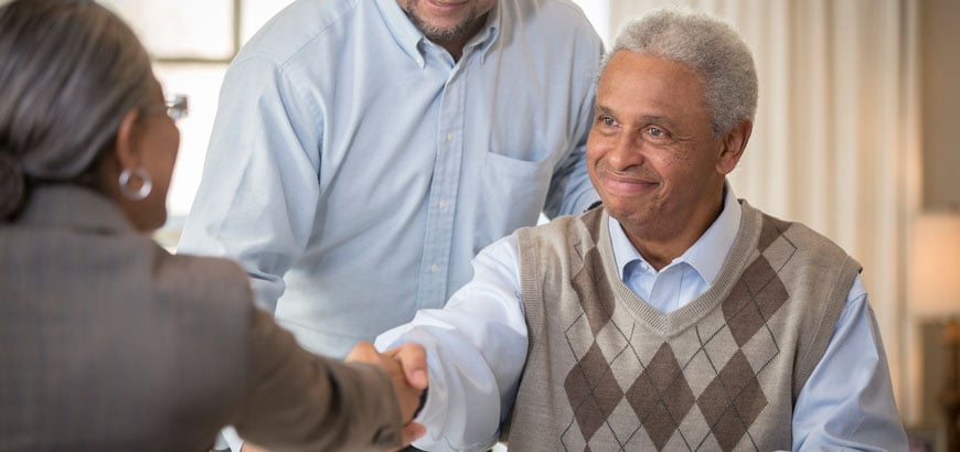 <span>Father and son shaking hands with businesswoman</span>