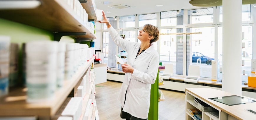 <span>Pharmacist standing and looking through medications</span>