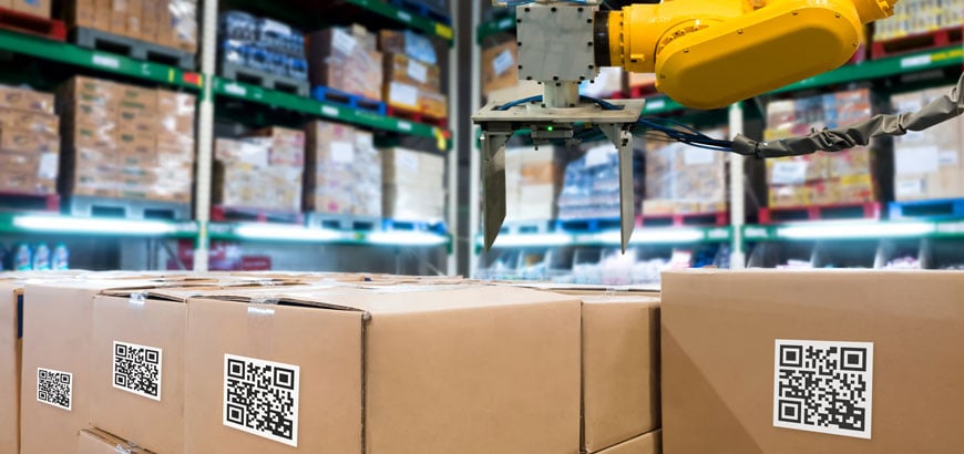 Warehouse boxes stacked under a mechanical arm.