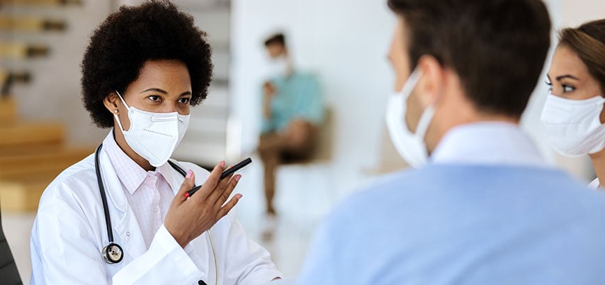 A doctor speaking with two patients