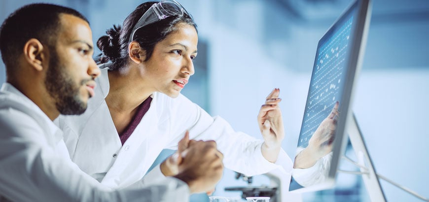 Two pharmacists looking at a computer screen together