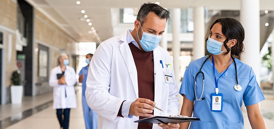 A doctor and a nurse reviewing a clipboard