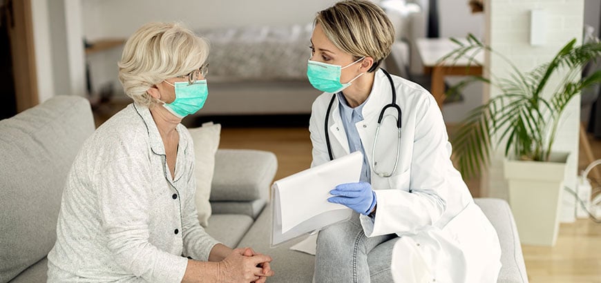 A doctor reviewing a chart with an elderly female patient