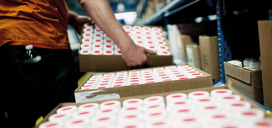 A person moving boxes filled with drugs in a distribution center