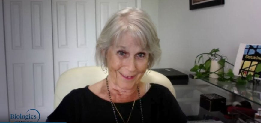 An older woman sitting in a chair smiling