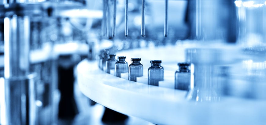 Close up of medicine vials on an assembly line