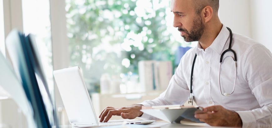 <i><span>Healthcare worker reading on computer. </span></i>