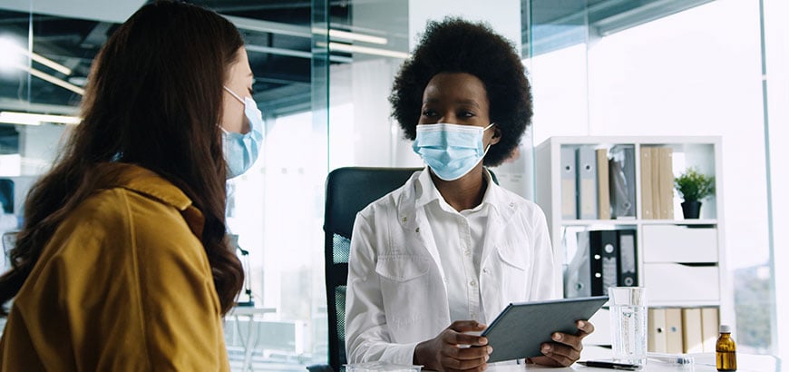 A pharmacist reviewing information on a tablet with a customer