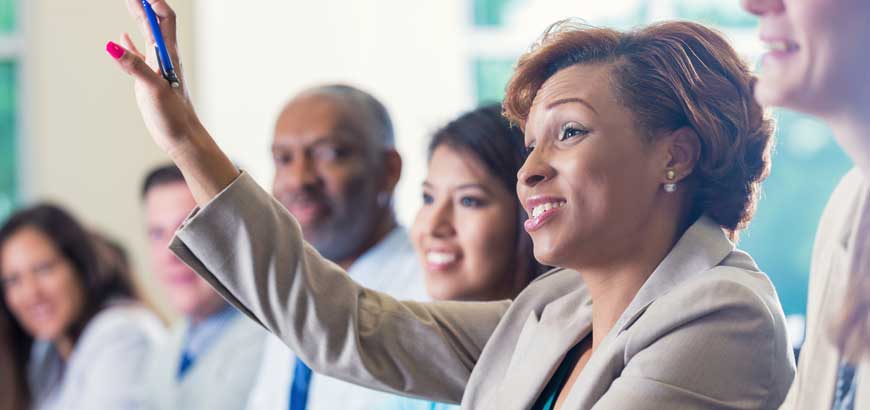 A woman raising her hand in a meeting