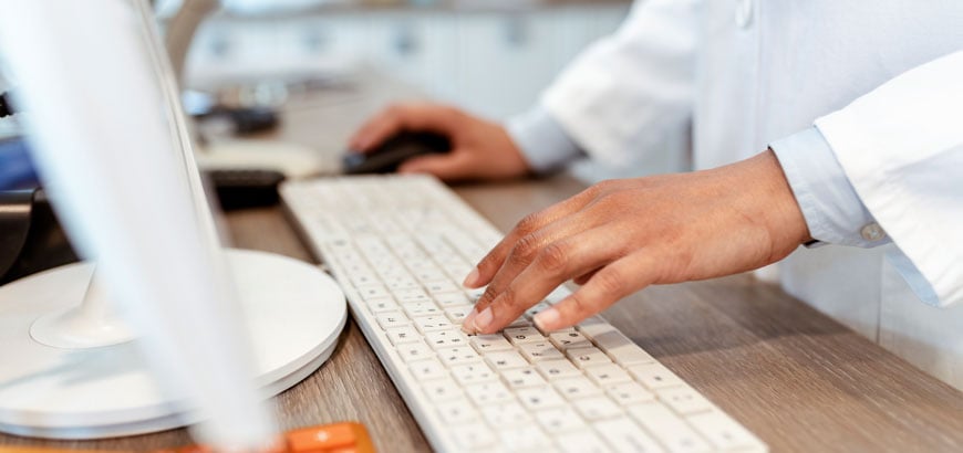 Close up of hands typing on a computer keyboard