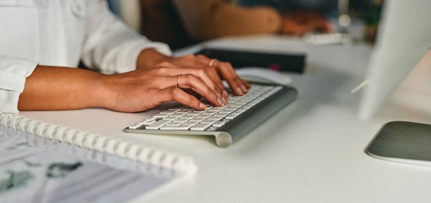 Close up of hands typing on a computer