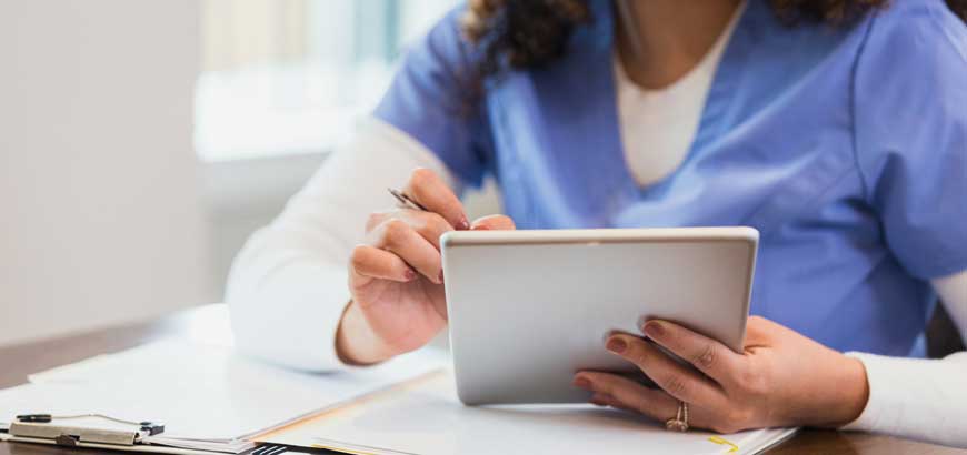 Close up of healthcare worker's hands holding an iPad