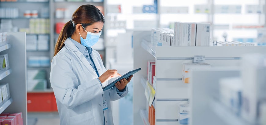 A pharmacist using a tablet in a pharmacy