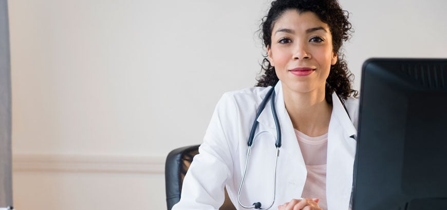 A healthcare worker sits at her desk