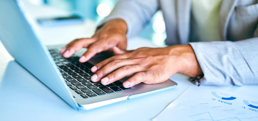 Close up of hands typing on a laptop keyboard