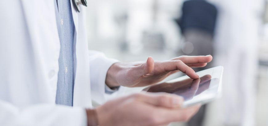 Close up of a doctor's hands, pressing on a tablet