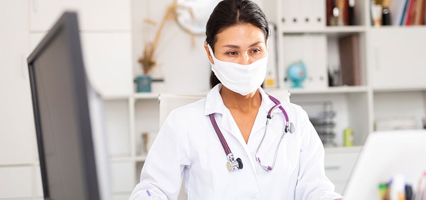 A doctor working at a computer workstation