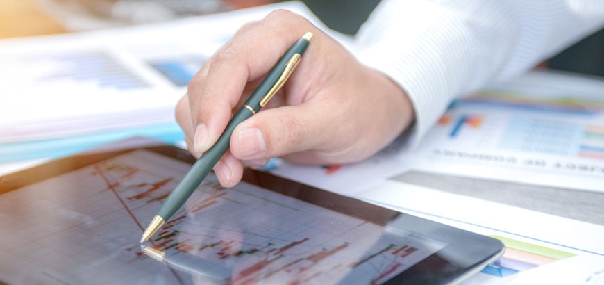 Close up of a hand holding a pen stylus to work on a tablet