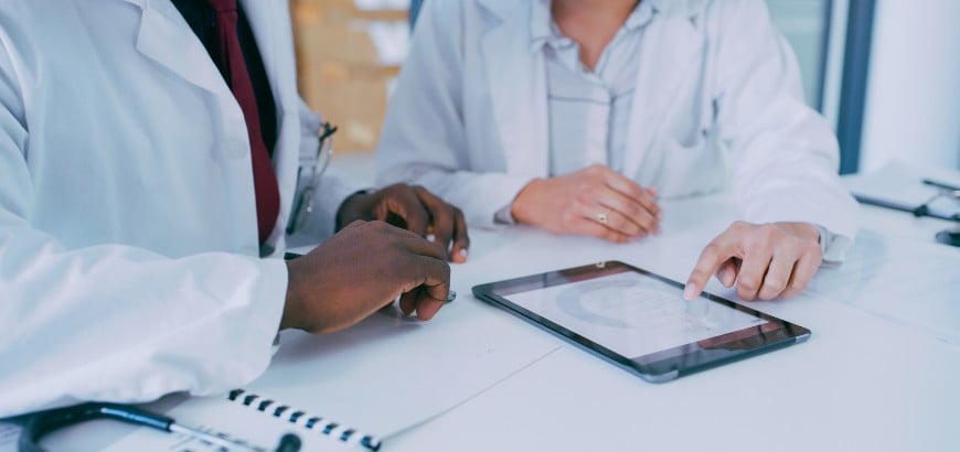 <span>Image of physician hands as they look over paperwork </span>