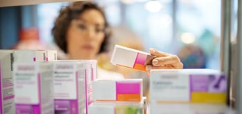 A pharmacist looking at medication boxes