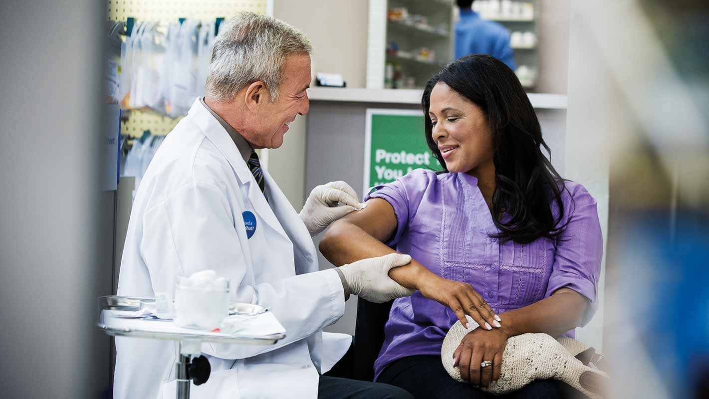 A pharmacist administering a flu shot