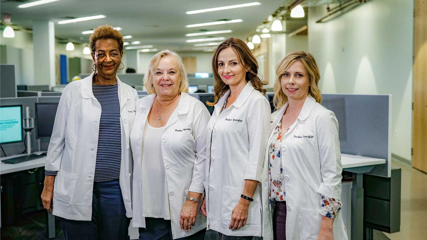 Four product specialists stand together in a hospital nurse's station