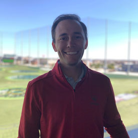 Daniel Zorola standing in front of a golf driving range