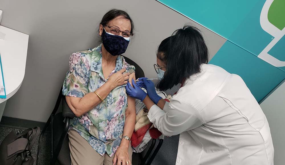 A pharmacist administering a COVID-19 vaccine to a patient