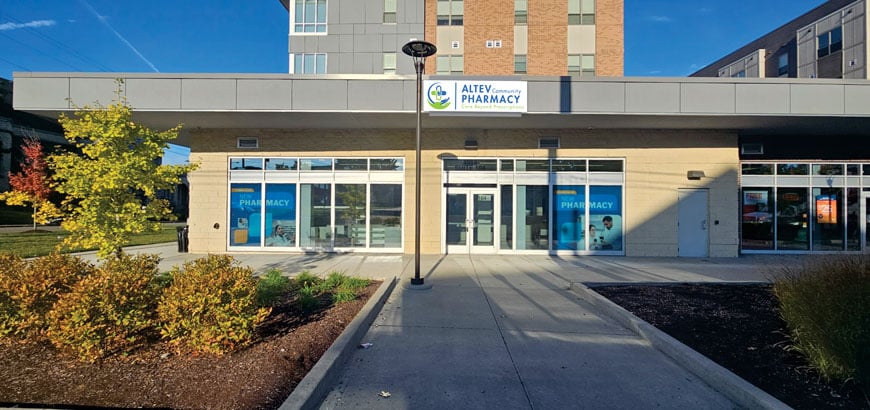 A modern pharmacy entrance with large windows and a sign reading 