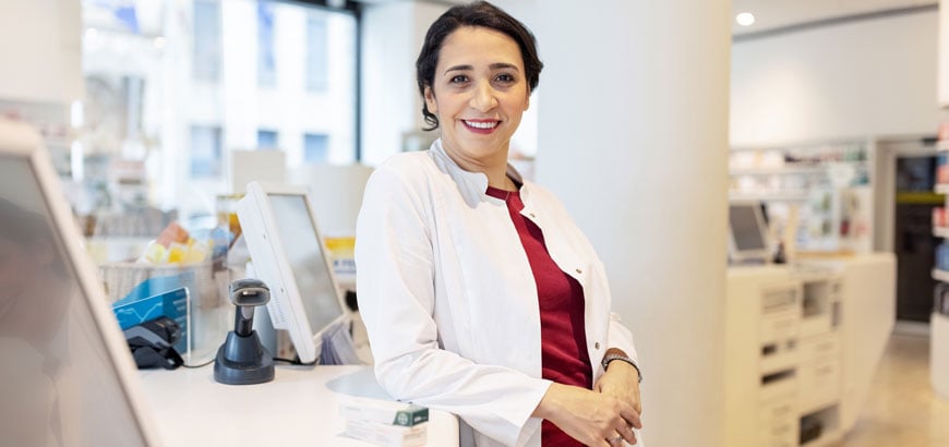 A pharmacist sits in the back of a pharmacy